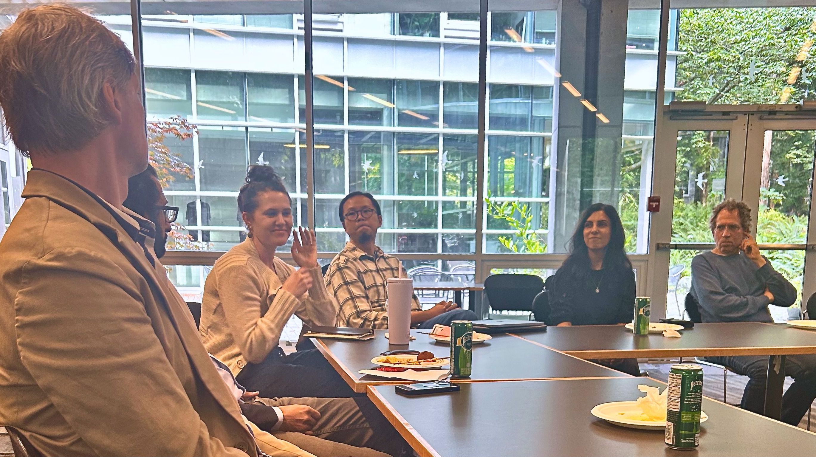 The image depicts cluster members and collaborators sitting around a table. From left to right are Jeffrey Byrne, Hasan Siddiqui, Anna Jurkevics, Shoufu Yin, Renisa Mawani and Bruce Baum.