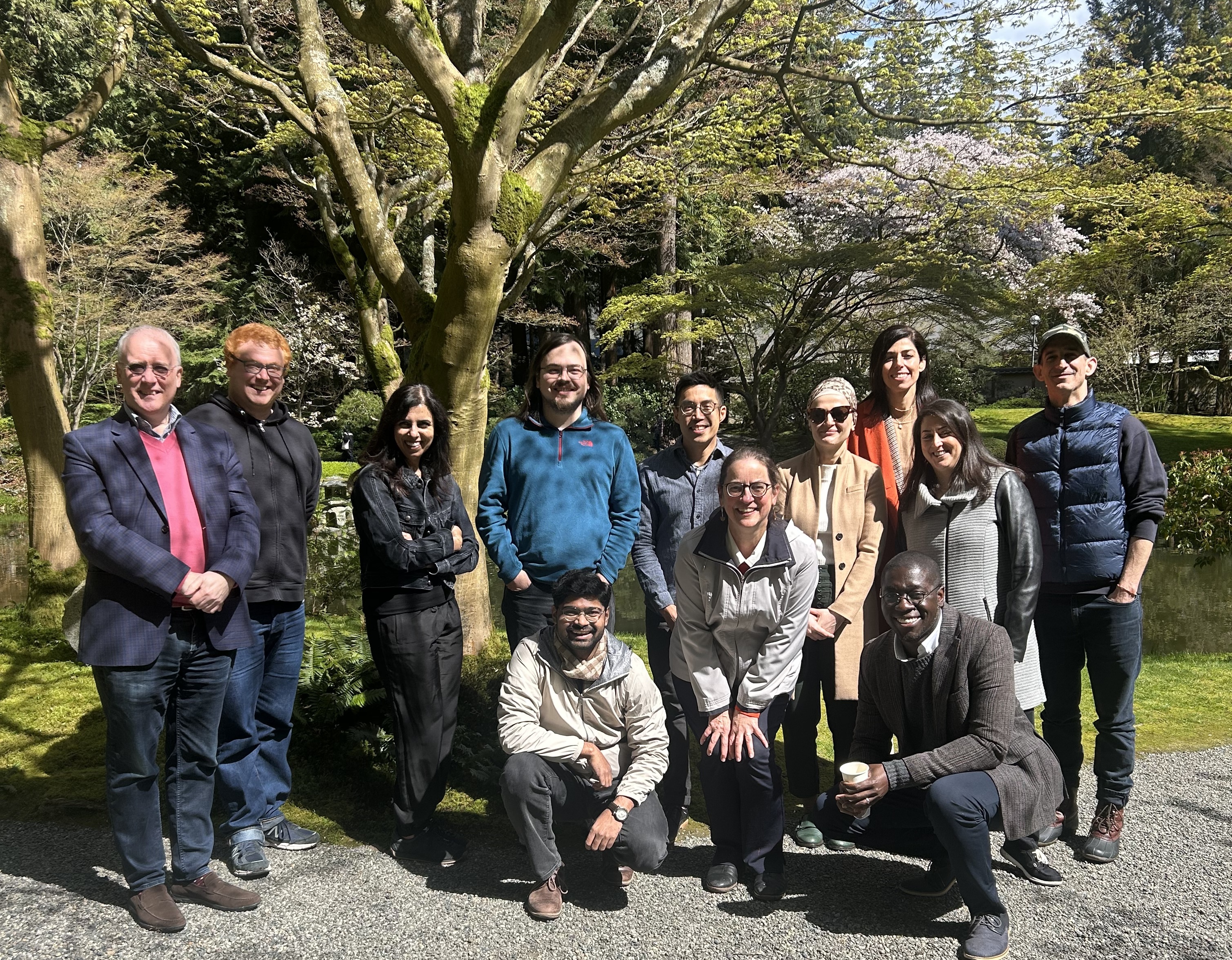 Group photo of symposium attendees outside of the place of many trees